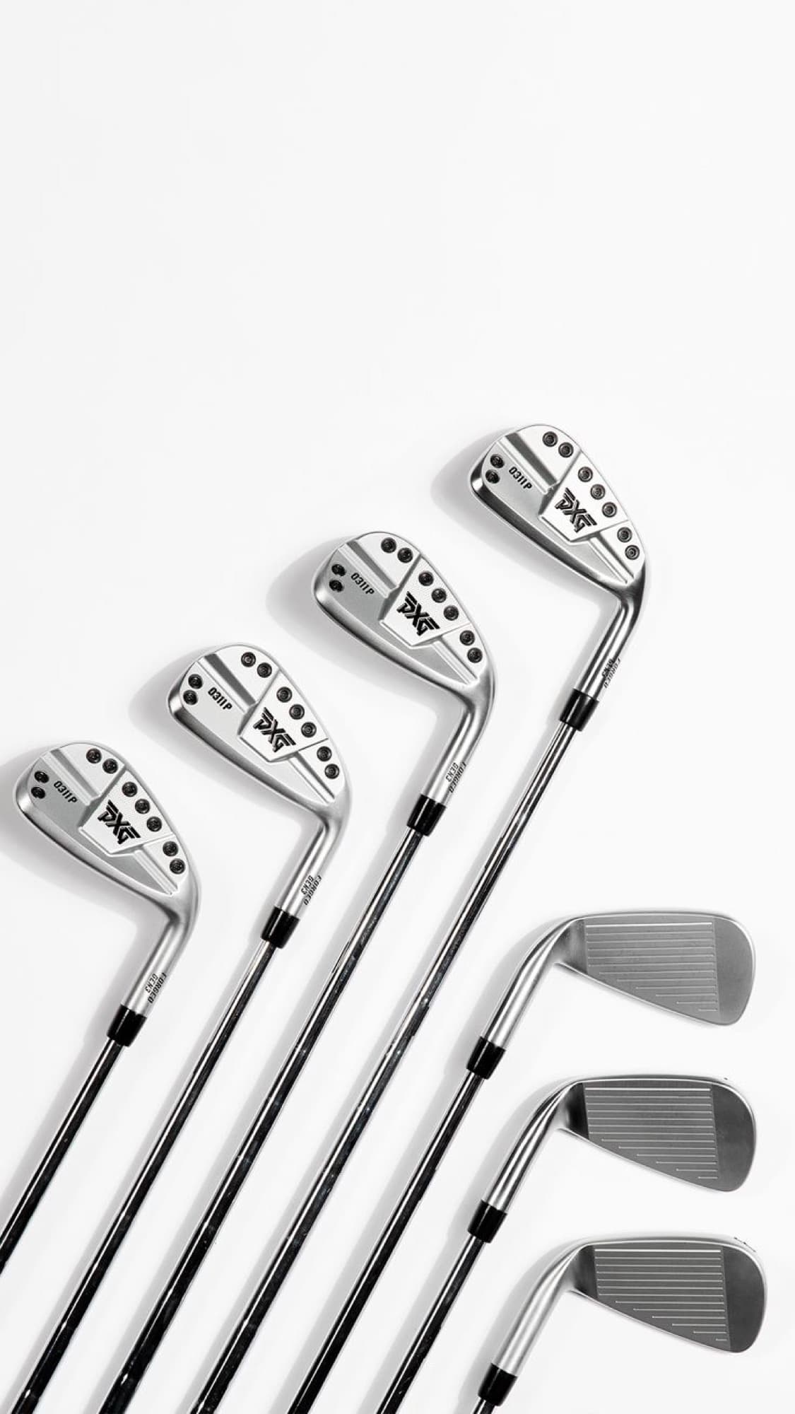 A set of irons fanned out on a white surface